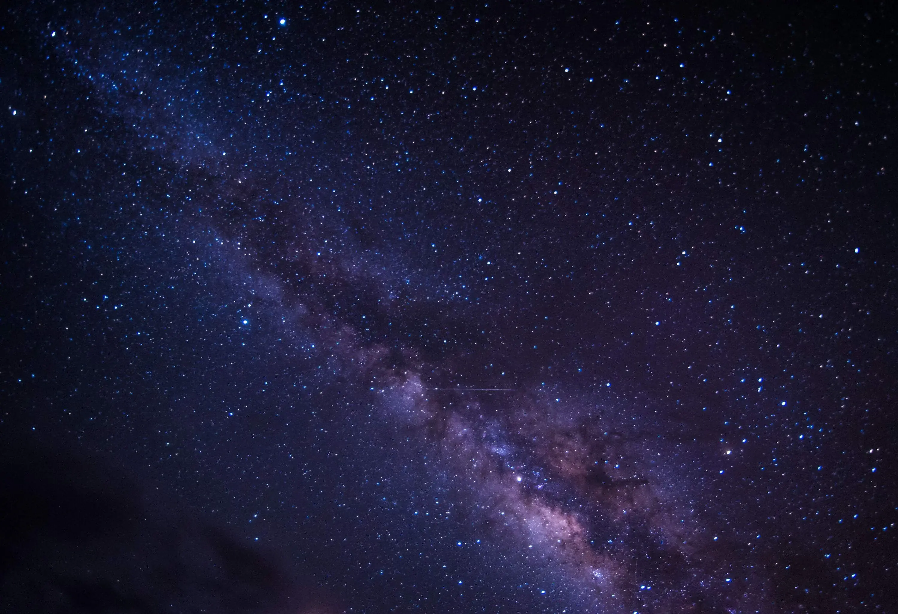 A mesmerizing image capturing the vastness of the Milky Way galaxy, adorned with a multitude of colourful stars and ethereal space dust.