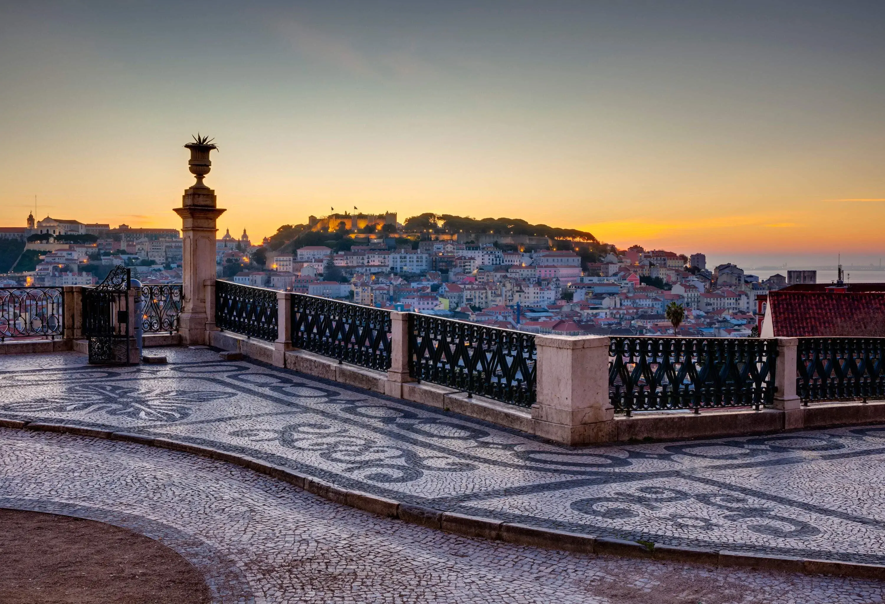 A picturesque populated city, seen from a rooftop captured against the scenic twilight sky.