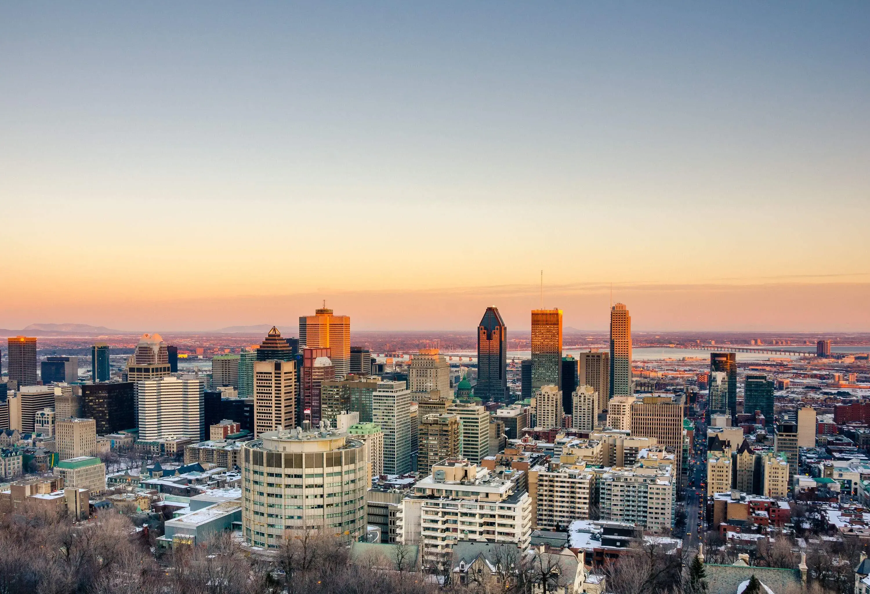 The sun rays line the top of tall buildings dominating the cityscape.