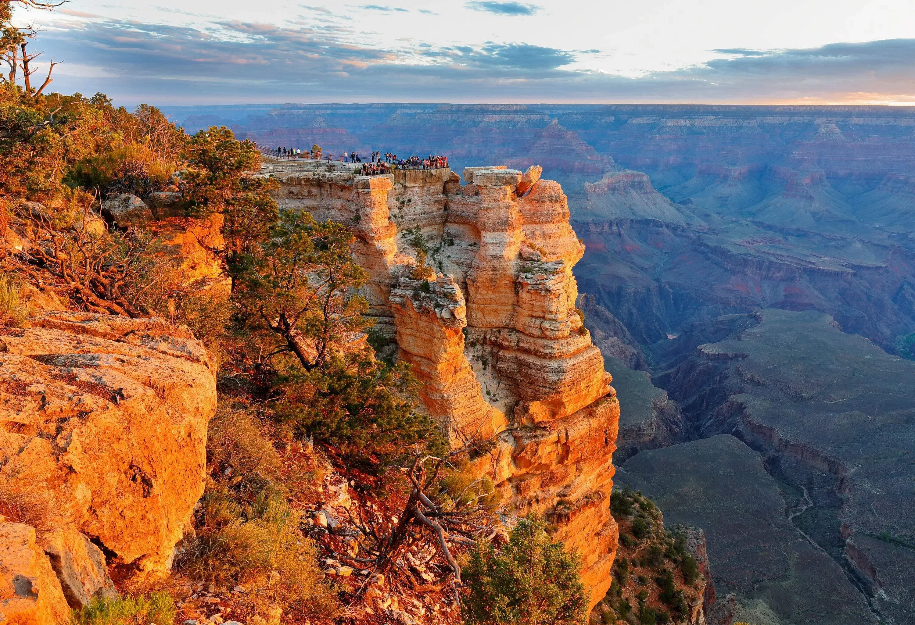 Tourists on a scenic viewpoint have a glimpse of the expansive view of a jaw-dropping world wonder, the Grand Canyon. 