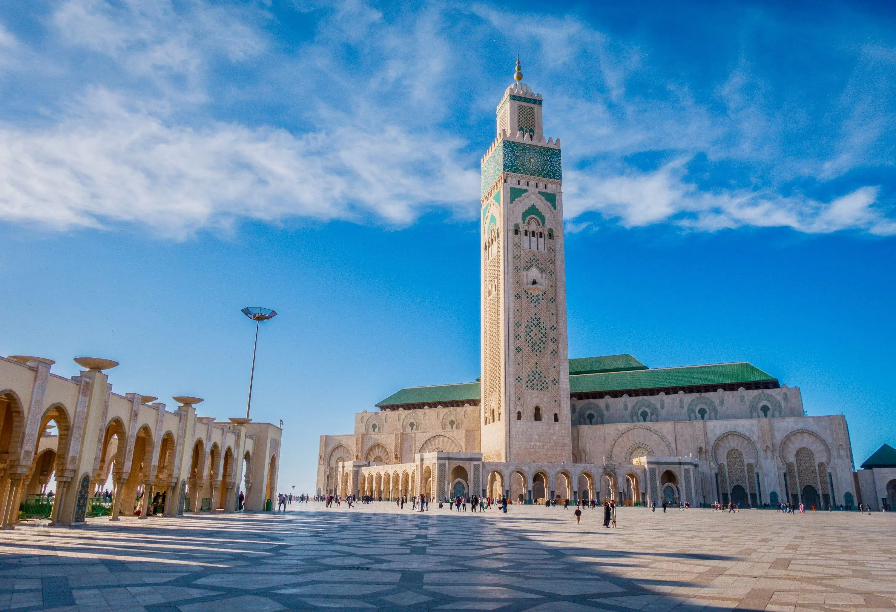 The towering building of the Hassan II Mosque, embellished with delicate Moroccan artistry, and its awe-inspiring minaret soaring into the sky.