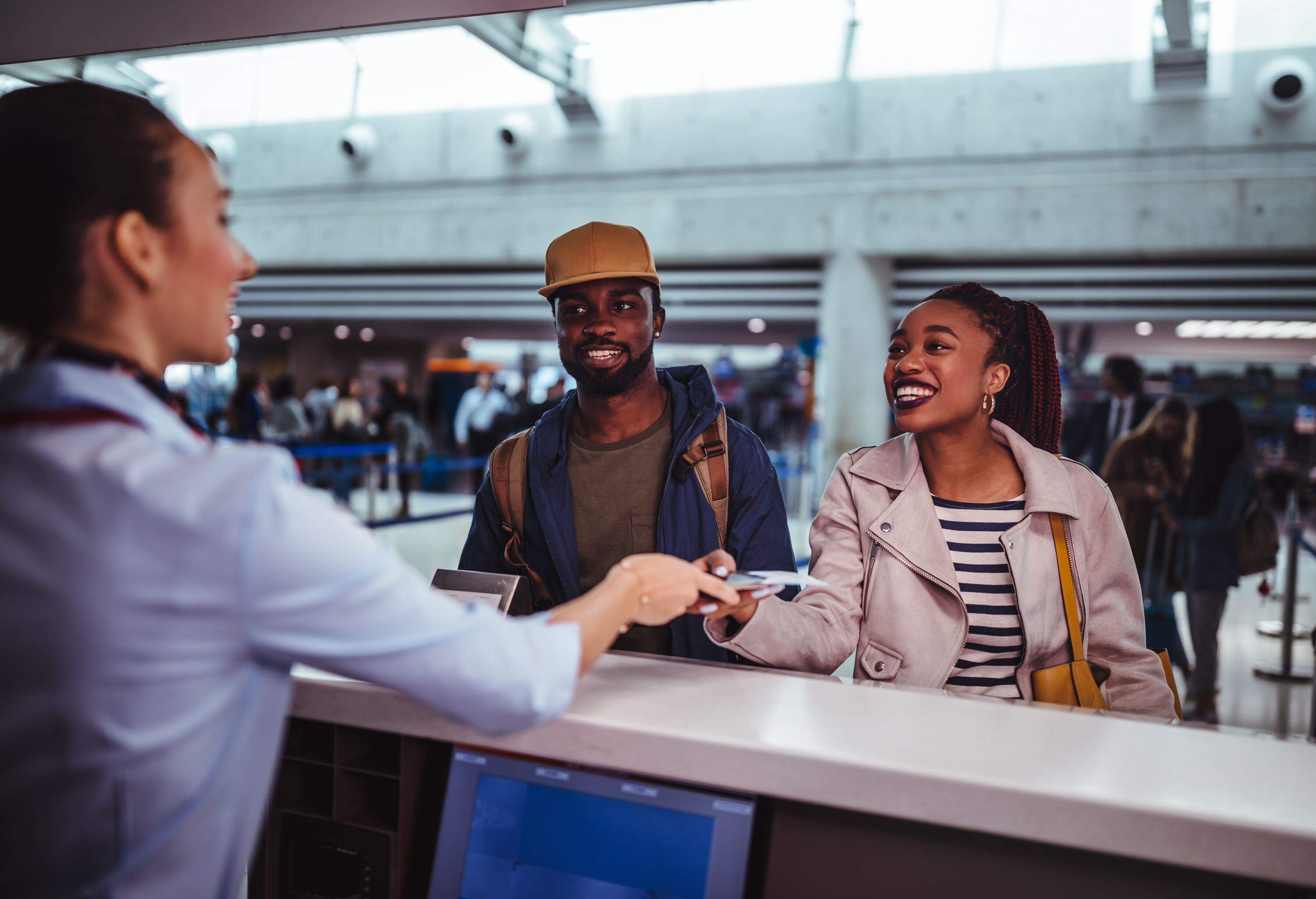 Young African-American couple doing check-in at airline check-in counter at international airport