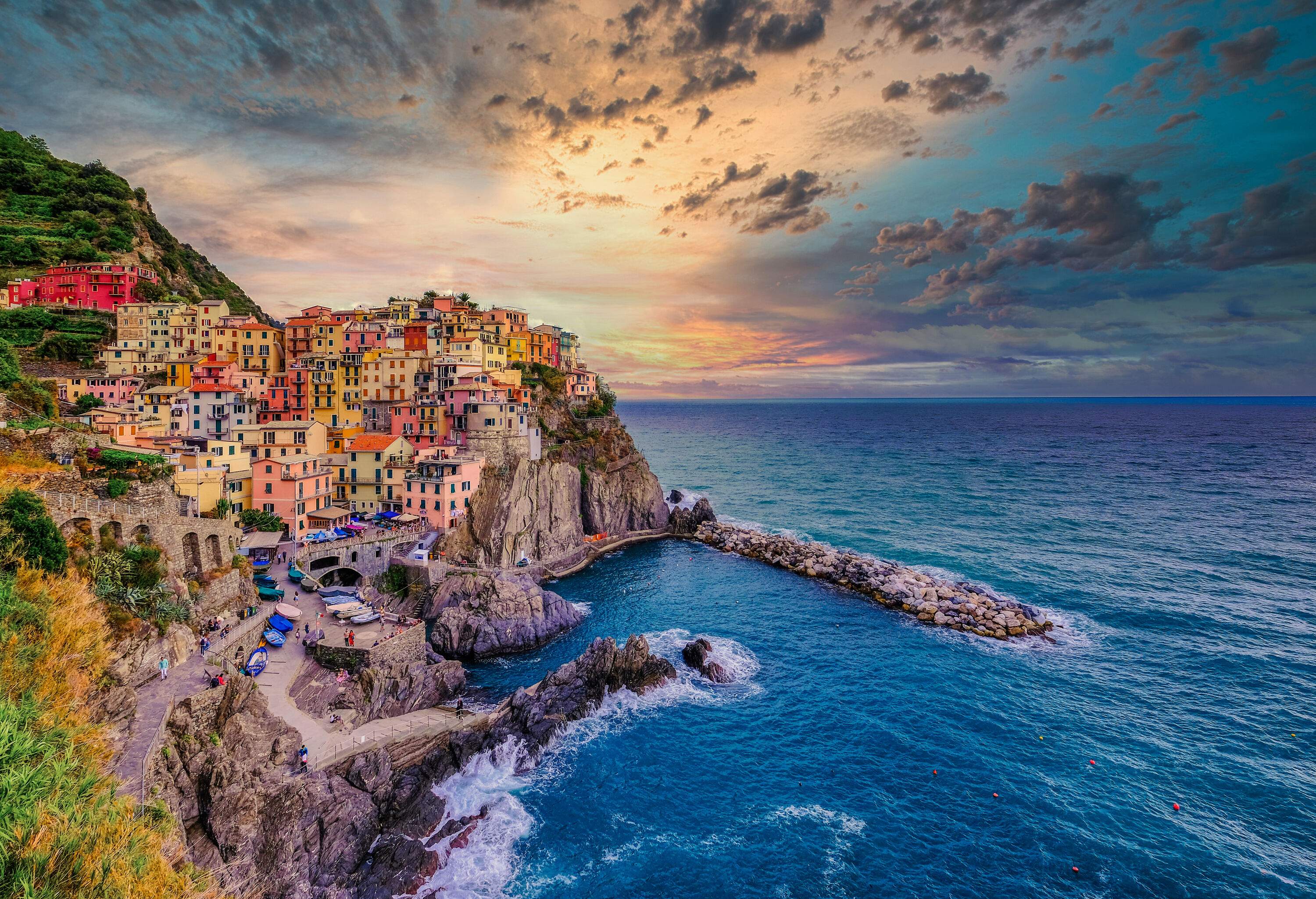 Colourful town houses perched on the side of coastal rock cliffs.