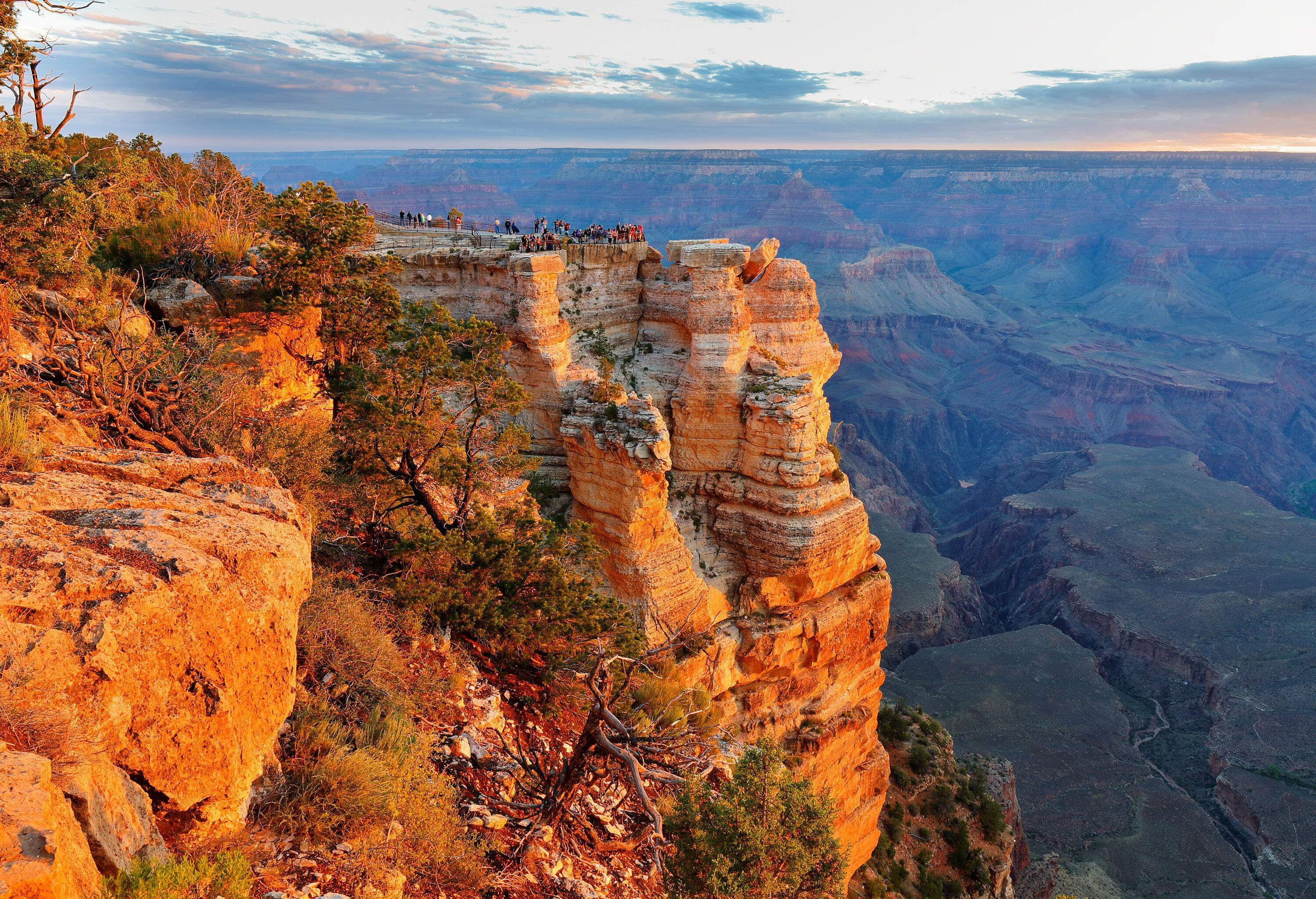 Tourists on a scenic viewpoint have a glimpse of the expansive view of a jaw-dropping world wonder, the Grand Canyon.