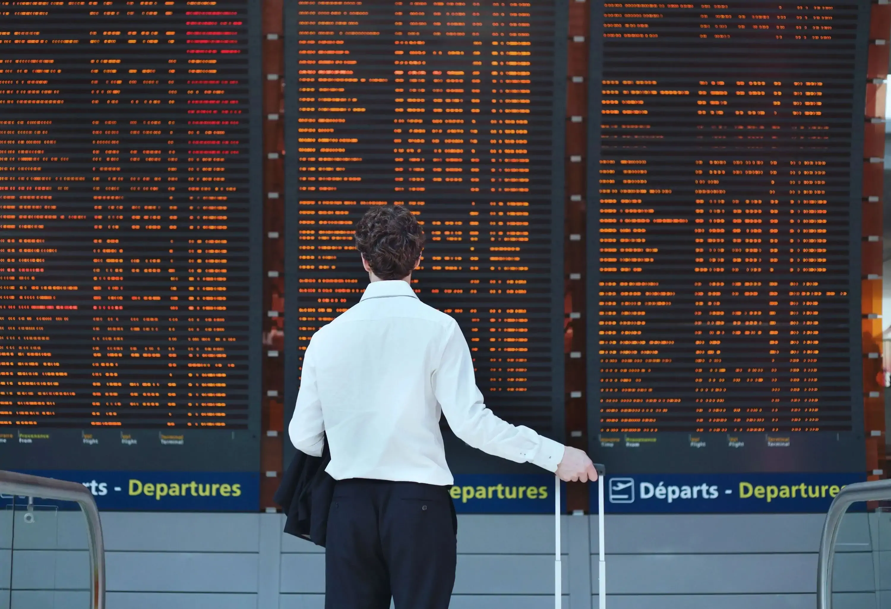 passenger looking at timetable board at the airport