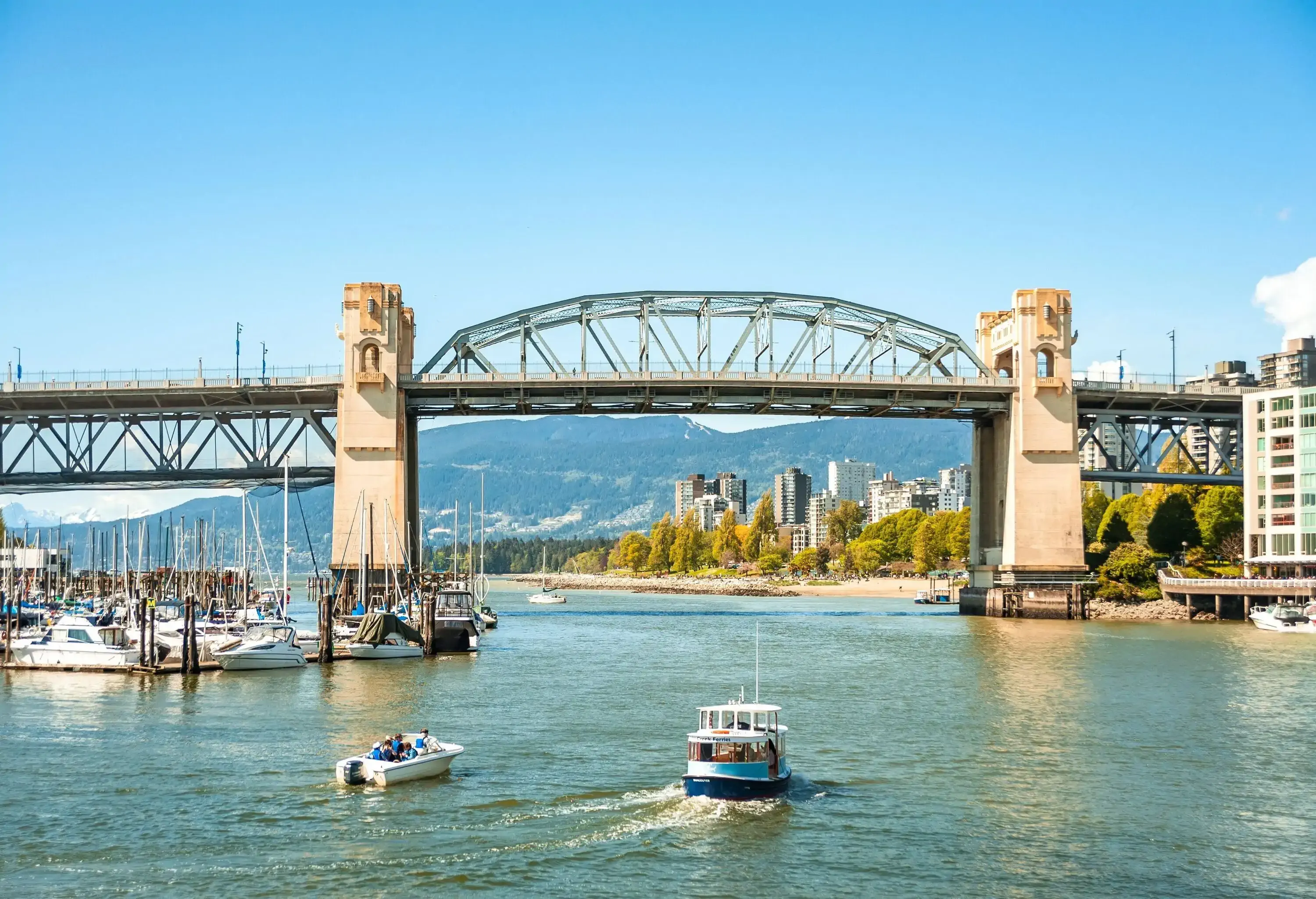 Boats cruising in False Creek towards the Burrard Street Bridge.