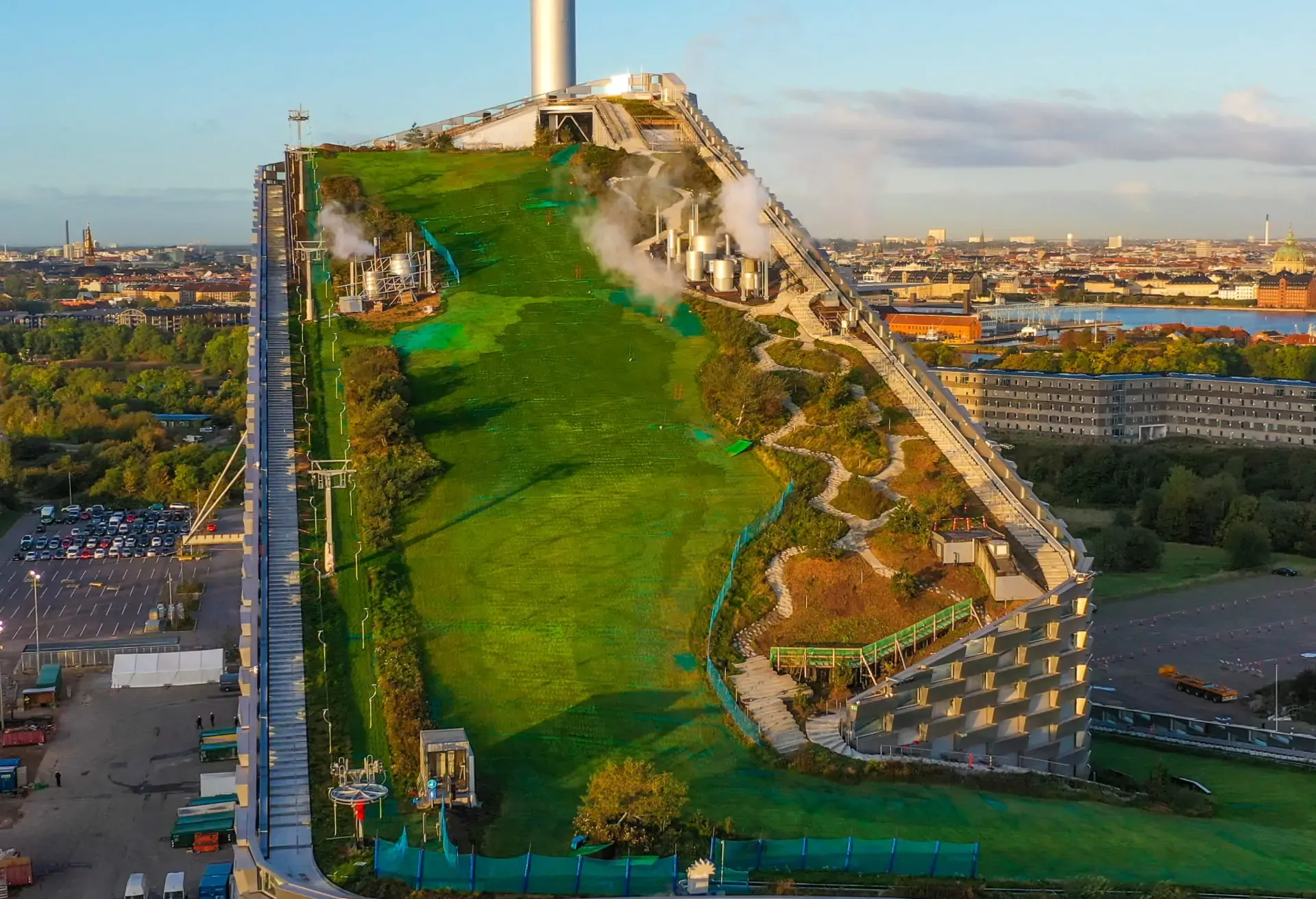 Industrial building with a green sloping roof featuring an artificial ski slope.